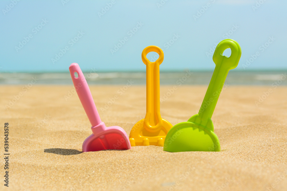 Set of colorful beach toys on sand near sea Set of colorful beach toys on sand near sea