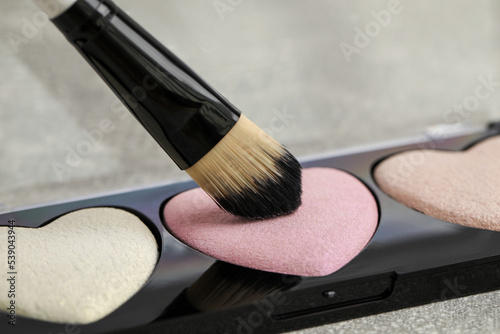Fotografie, Tablou Palette of heart shaped eyeshadows with brush on grey table, closeup