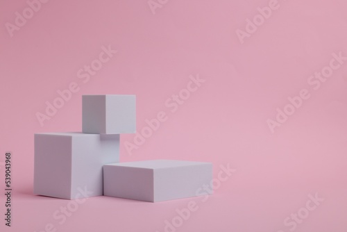 Scene for product presentation. Podiums of different geometric shapes on pink background, space for text © New Africa