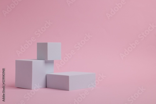 Scene for product presentation. Podiums of different geometric shapes on pink background  space for text