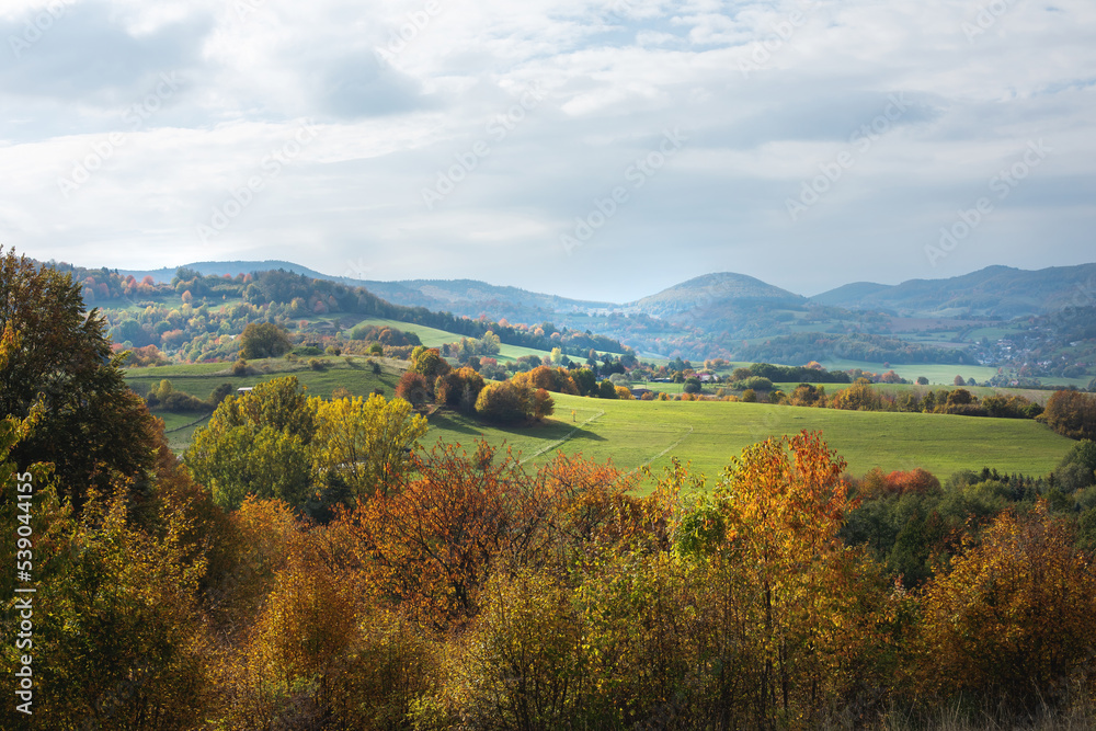Rural landscape on a sunny day in autumn.Mountains in background.