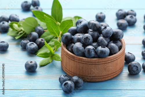 Tasty fresh blueberries on light blue table, closeup