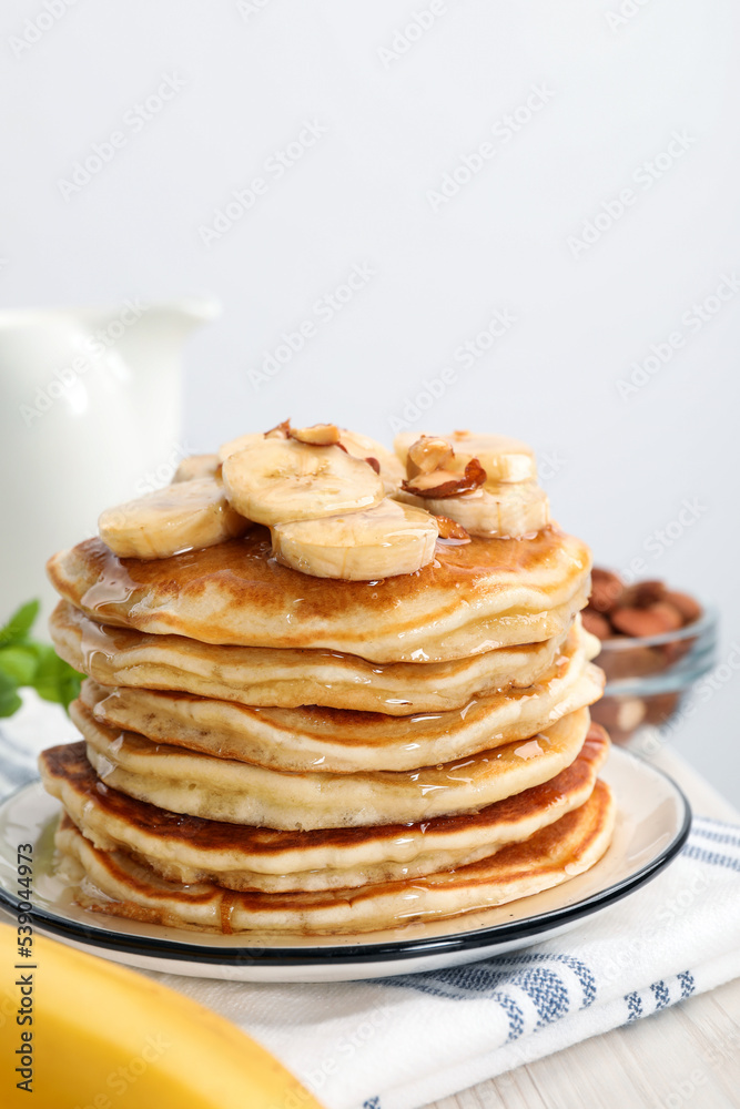 Tasty pancakes with sliced banana served on white wooden table, closeup. Space for text