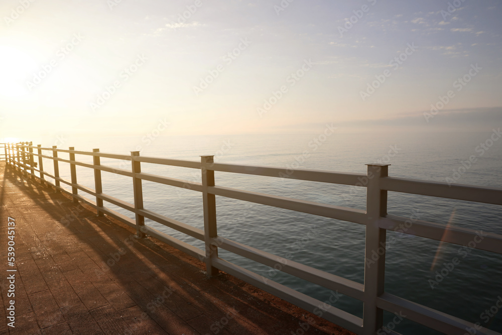 Picturesque view of pier near sea at sunrise