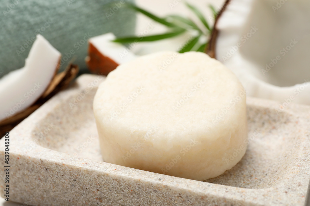 Solid shampoo bar in stone holder, closeup. Hair care