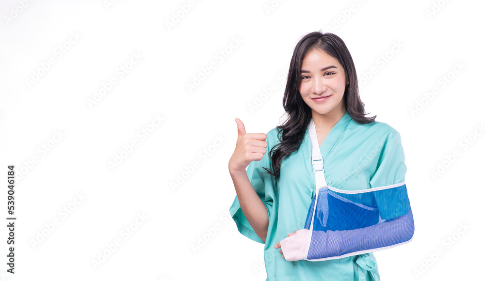 Injury asian woman wear patient broken arm hand splint showing thumbs up for good service health care insurance on white background. Happy female accident problem hand splint over isolated. Insurance Injury asian woman wear patient broken arm hand splint showing thumbs up for good service health care insurance on white background. Happy female accident problem hand splint over isolated. Insurance