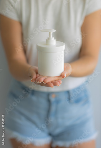The girl holds in her hands a bottle of gel for intimate hygiene. Women Health. Soft focus