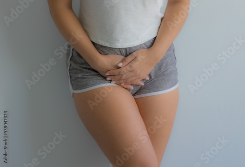The girl holds her stomach with her hands. Diseases of the genitourinary system. Women Health. Soft focus
