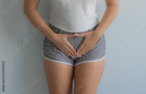 The girl holds her stomach with her hands. Diseases of the genitourinary system. Women Health. Soft focus photo