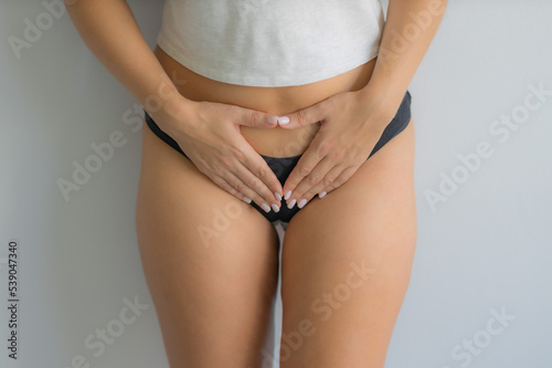 The girl holds her stomach with her hands. Diseases of the genitourinary system. Women Health. Soft focus 