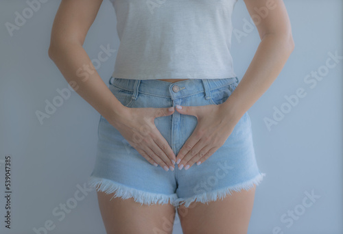The girl holds her stomach with her hands. Diseases of the genitourinary system. Women Health. Soft focus
