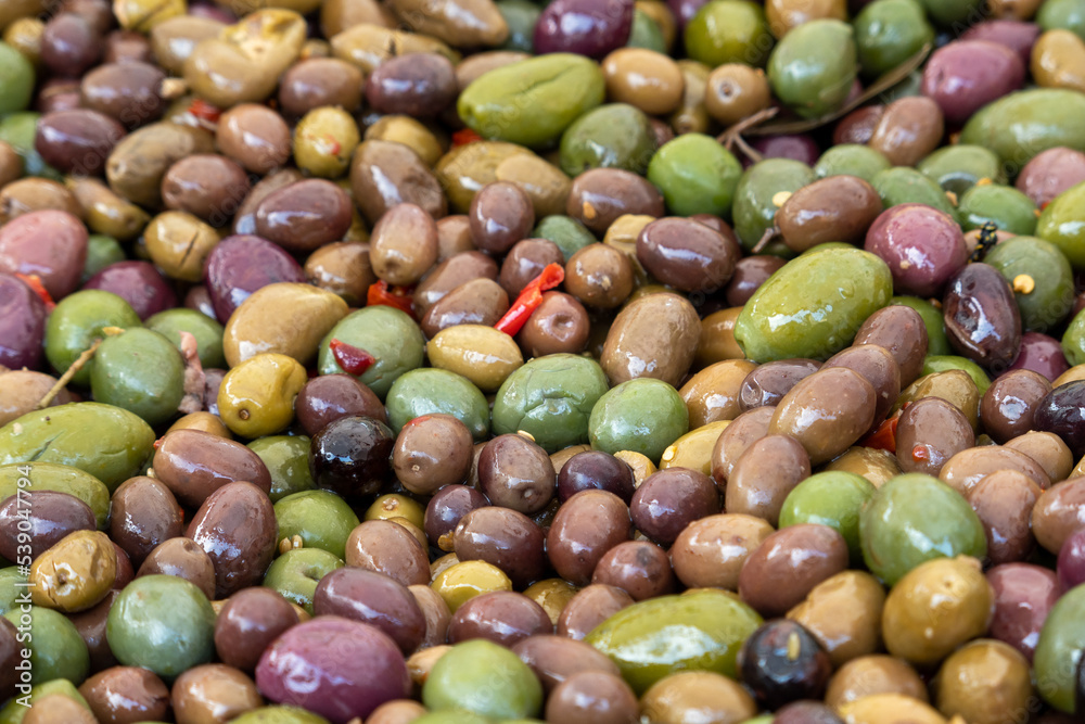 Spicy green olives are poured with olive oil with spices. Top view. Spicy green olives are poured with olive oil with spices. Top view.