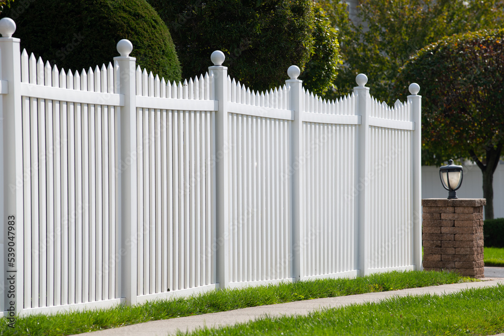 White vinyl fence in residential neighborhood White vinyl fence in residential neighborhood