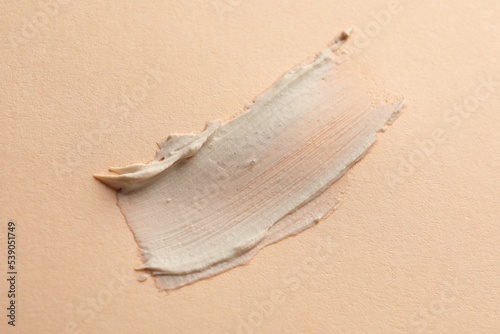 Sample of face mask on beige background, top view