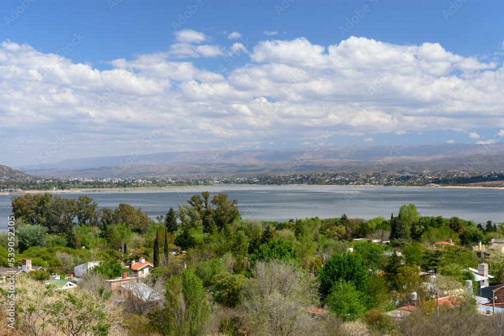 Vista del valle de Punilla con el lago al centro de la imagen. Casas entre los árboles