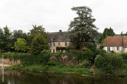 Wide shot of the town of La Vezere with trees and a river in Montignac, France. photo