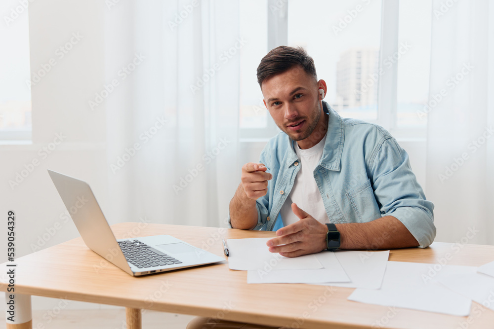 Happy enthusiastic smiling nice-looking young businessman show point finger at camera in office communicates with candidate. Copy space for ad. Remote Job, Technology And Career Profession Concept Happy enthusiastic smiling nice-looking young businessman show point finger at camera in office communicates with candidate. Copy space for ad. Remote Job, Technology And Career Profession Concept