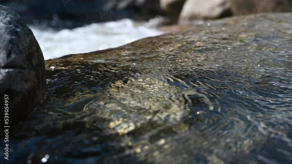 Water from a mountain stream flows over rocks (slow motion) Water from a mountain stream flows over rocks (slow motion)