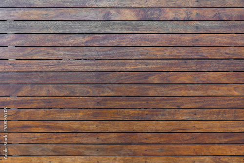 panoramic texture of a mistreated varnished wood wooden fence surface with metal rivets pattern