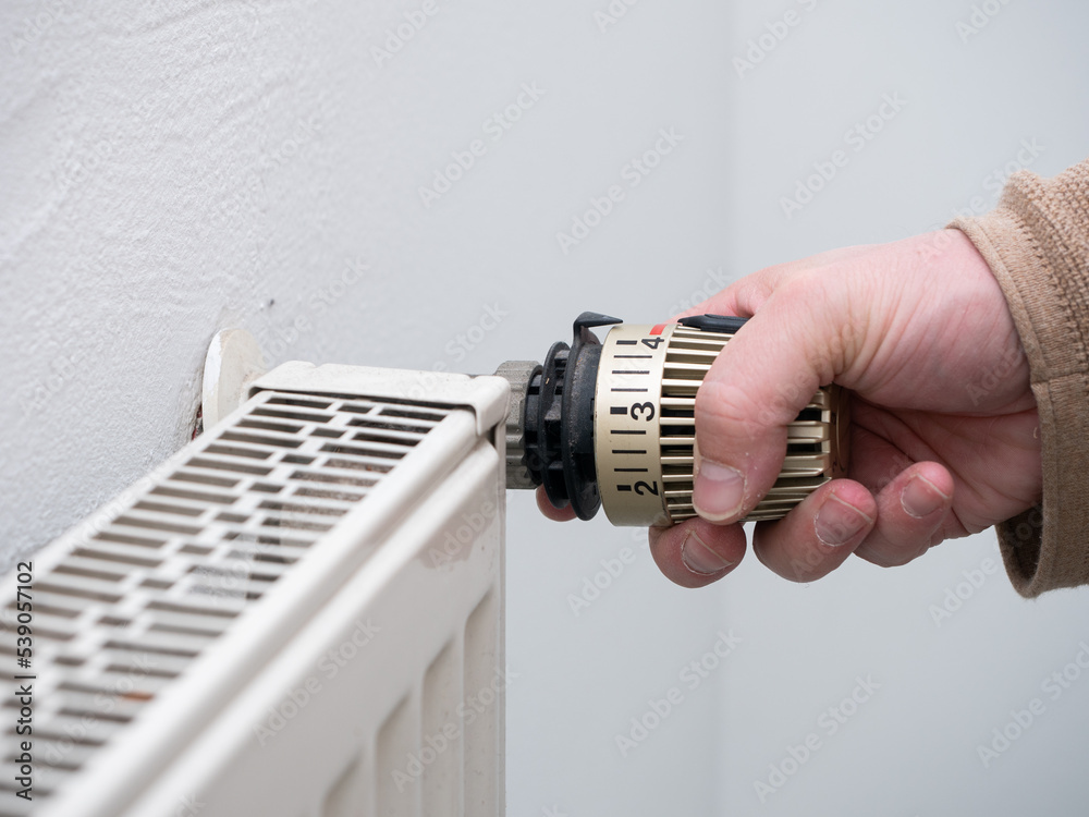 Homeowner desperately trying to save on heating bills by turning down the heat.
Homeowner desperately trying to save on heating bills by turning down the heat.