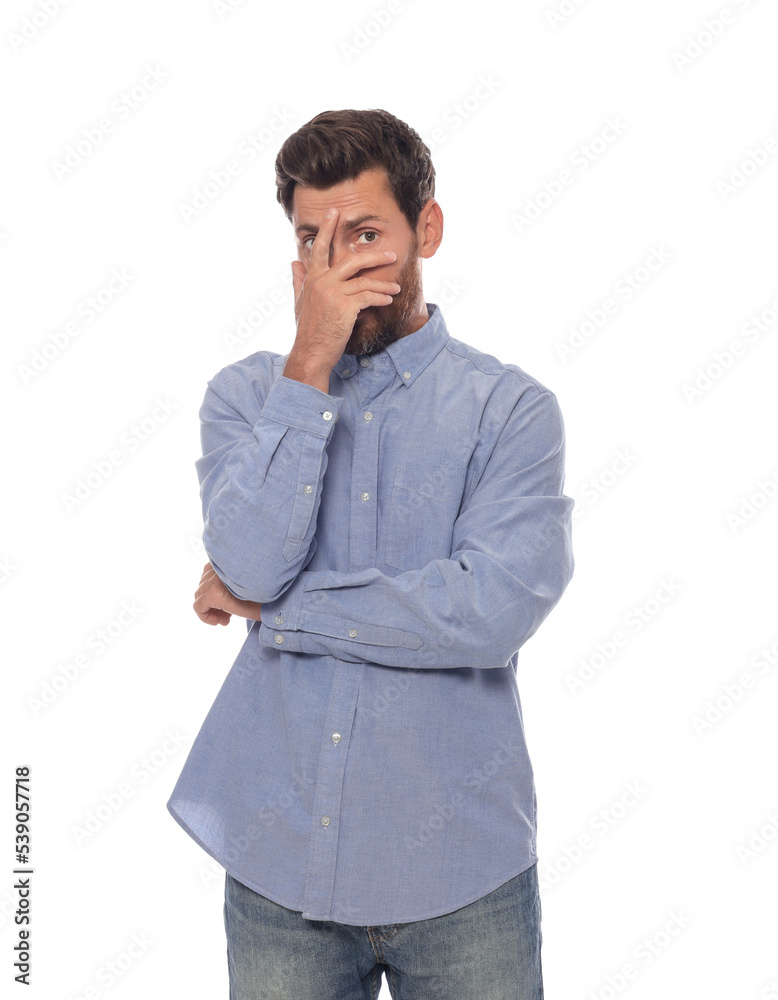 Embarrassed man covering face with hand on white background Embarrassed man covering face with hand on white background