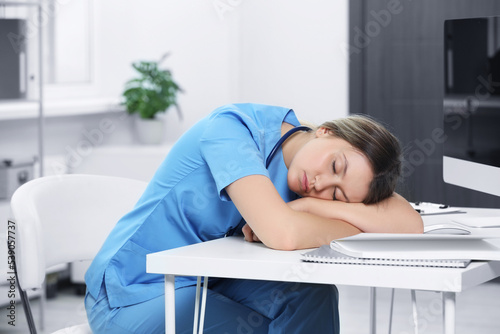 Exhausted doctor sleeping at workplace in hospital