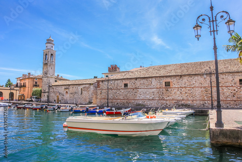 Idyllic lake Garda coastline in Lazise with boat, Northern Italy