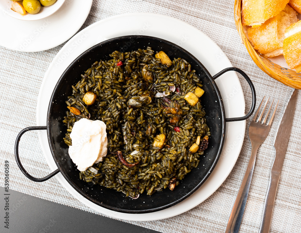 Φωτογραφία Traditional Valencian paella Arroz negro with squid ink, shrimps and mussels ser