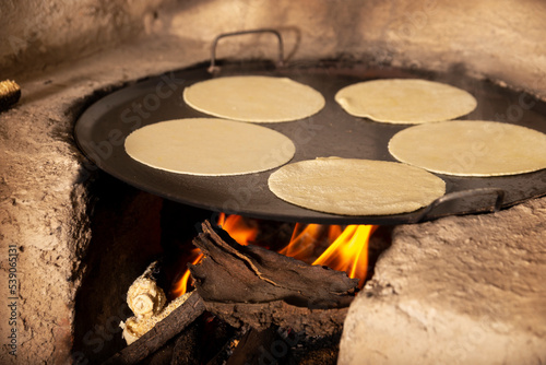 Handmade corn tortillas cooked in a traditional rustic wood stove called 