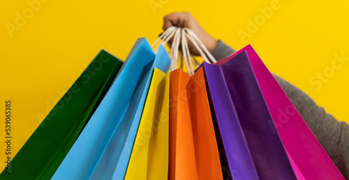 Close-up of a woman's hands holding colorful shopping bags. Copy space. Shopping Concept