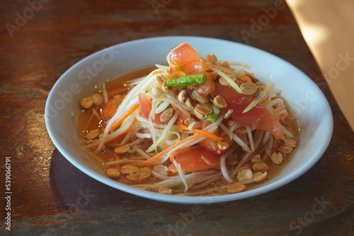 Fresh Som Tum Thai, Thai Style Papaya Salad on blue plastic dish, on wooden table background, food, nature, vegetable