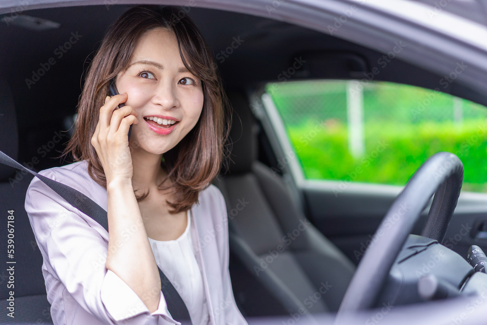 スマホを使いながら車を運転する女性