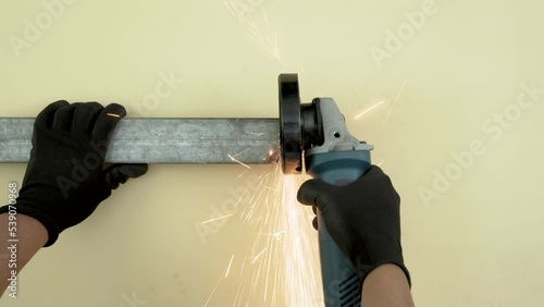 top view footage professional worker wear black gloves using angle grinder cutting straight galvanized steel with copy space
