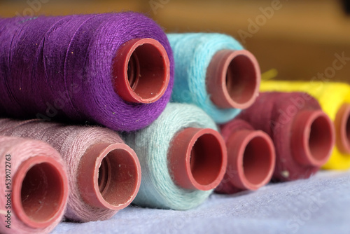 Stacks of colourful yarn spools, tube yarn and linen yarn.