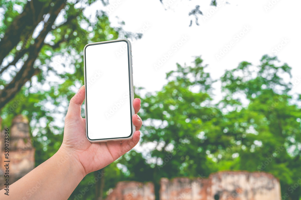 Close up women using a smartphone with empty white screen at the outdoor. Close up women using a smartphone with empty white screen at the outdoor.