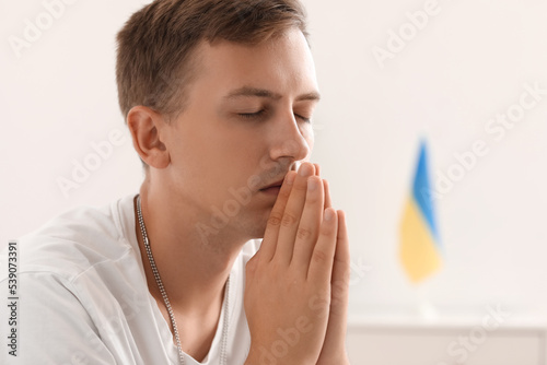 Handsome young man praying ...