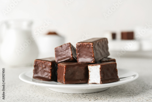 Plate with tasty bird s milk candies on light background  closeup