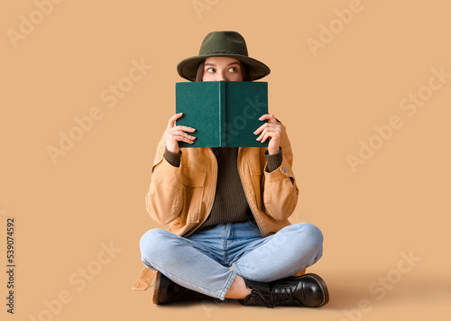 Young woman in hat reading ...
