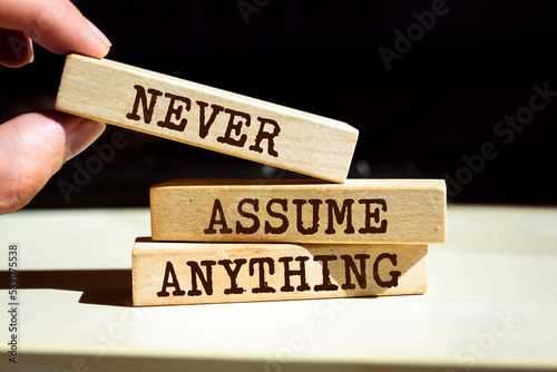Wooden blocks with words 'Never Assume Anything'. photo
