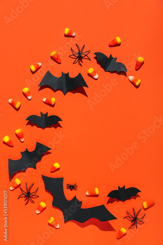 Frame made of paper bats  spiders and candy corns on red background