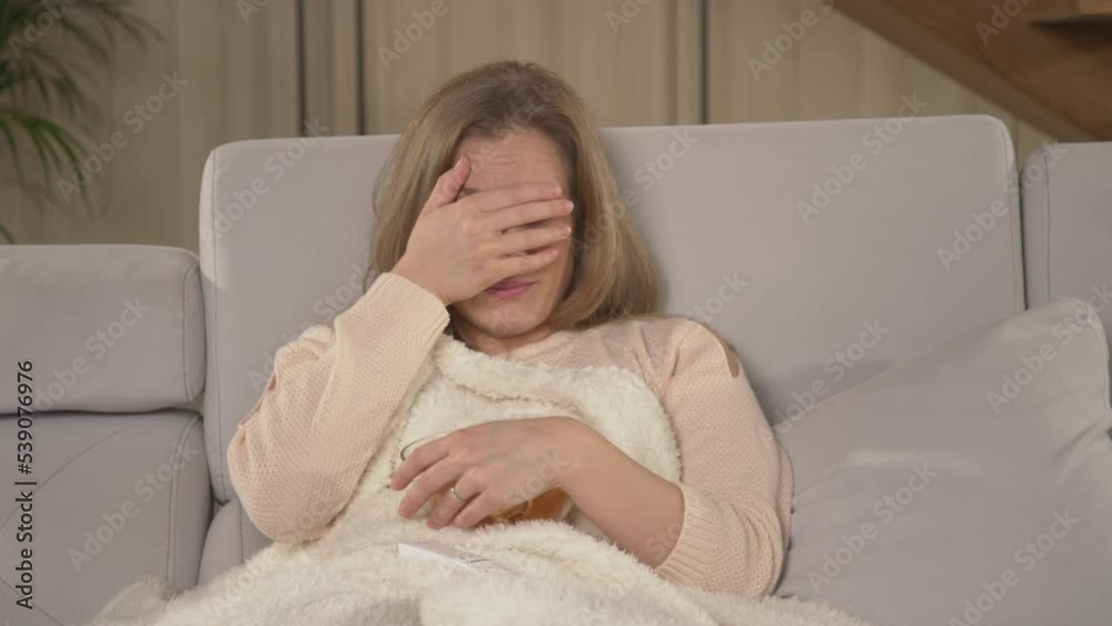 CLOSE UP: Woman watching thriller movie and hiding behind blanket at scary scenes. Young lady getting scared while watching TV movie. Female person chilling in front of television on a winter evening. CLOSE UP: Woman watching thriller movie and hiding behind blanket at scary scenes. Young lady getting scared while watching TV movie. Female person chilling in front of television on a winter evening.