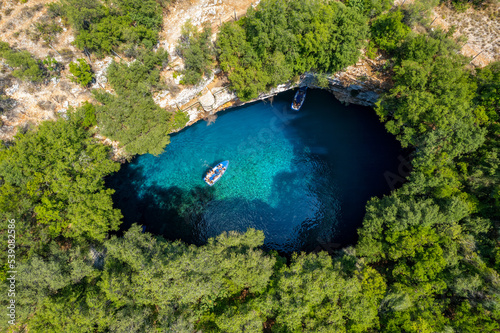 Aerial view of the iconic Melissani cave with the crystal clear turquoise waters located near port of Sami, Kefalonia island, Ionian, Greece