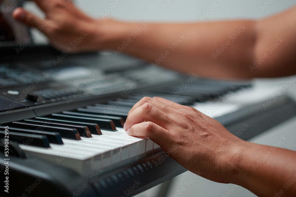 Close-up of male hands playing keyboard