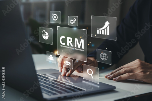 Businessman using laptop with CRM icon on virtual screen, Customer Relationship Management for business technology concept. photo