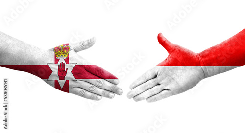 Handshake between Indonesia and Northern Ireland flags painted on hands, isolated transparent image. photo
