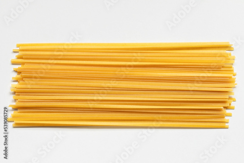 Durum fettuccine pasta on white background. Raw spaghetti or noodles