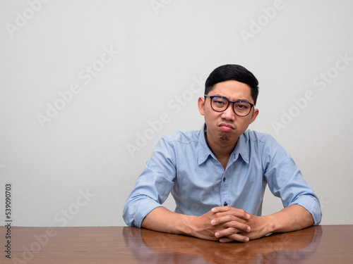 Asian bisinessman sit alone at table feels bored and tried photo