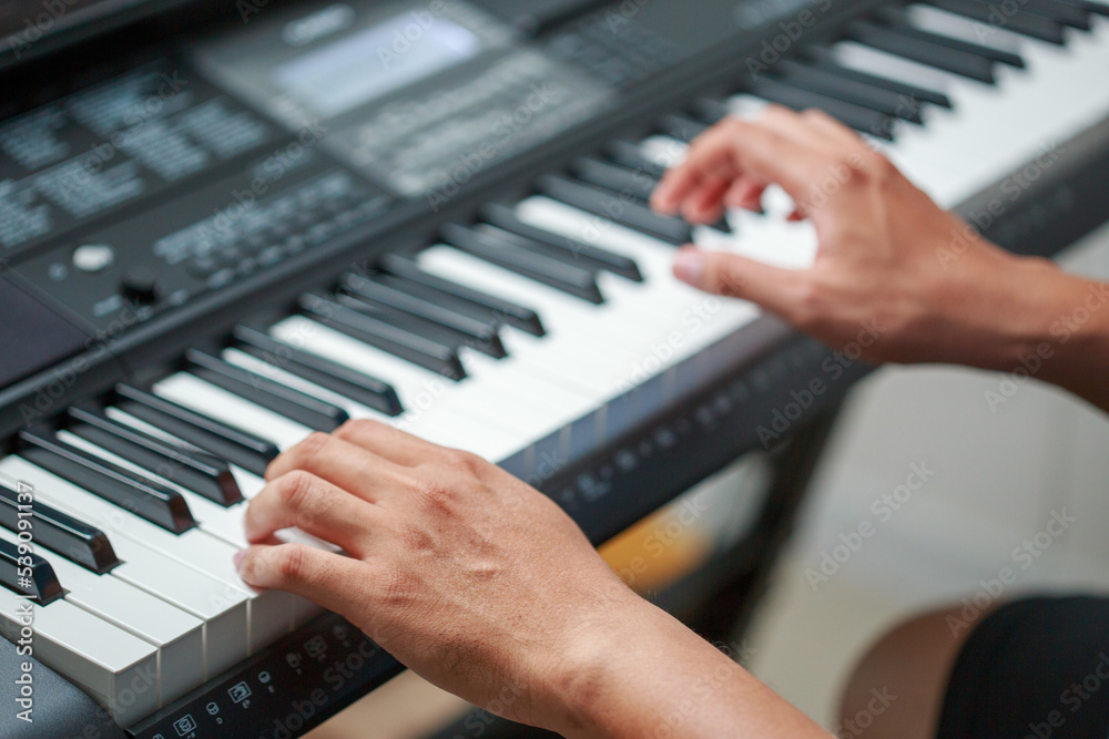 Fototapeta premium Man playing Electronic piano keyboard. Closeup of black and white piano keys.