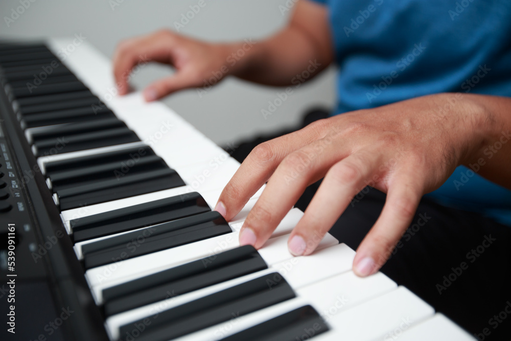 Man playing Electronic piano keyboard. Closeup of black and white piano keys.