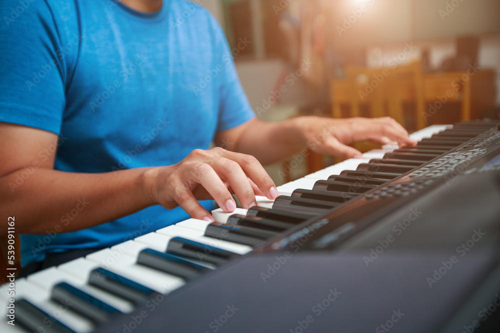 Fototapeta premium Man playing Electronic piano keyboard. Closeup of black and white piano keys.